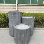 A 56 cm diameter Fluted Garden Pot in raw concrete color, featuring a beautifully textured ribbed design. The pot stands tall, showcasing its elegant and modern aesthetic, perfect for both indoor and outdoor use. Its durable yet lightweight construction makes it an ideal choice for a variety of plants and garden settings.